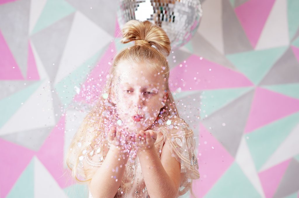 Girl blowing glitter during a photo party mini session at Photo Party London