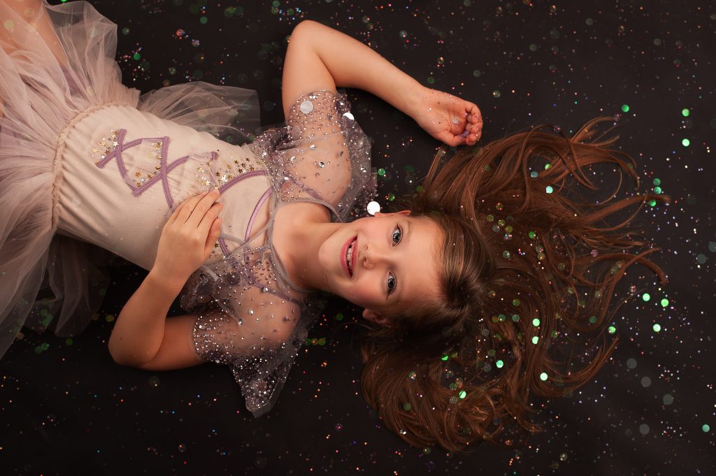 Girl laying on floor in party dress during a photo party